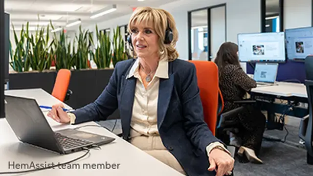 Portrayal of a professional woman sitting at desk wearing a headset